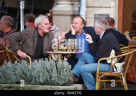 Männer sprechen an einem Tisch vor einer Bar in Krakau, Polen Stockfoto