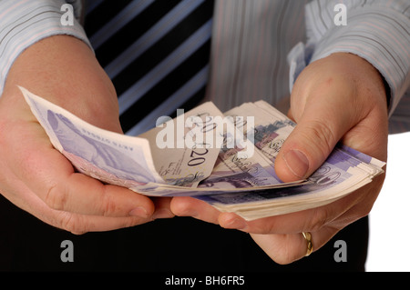 Mann seine zwanzig Pfund-Banknoten zählen Stockfoto