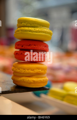 Makronen in verschiedenen Farben übereinander im Schaufenster abgesteckt. Stockfoto