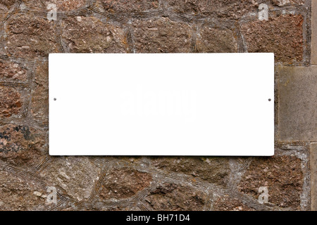 Weißes Schild auf einer alten Steinmauer leer ist, Ihre eigene Nachricht anzufügen. Stockfoto