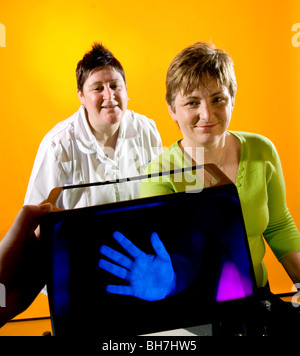 Krankenschwestern zeigen, wie die Bakterien auf den Händen bleiben können, wenn Sie nicht richtig gewaschen, mit Gel, das unter UV-Licht leuchtet. Stockfoto