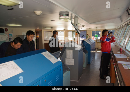 Kapitän und Crew-Mitglieder auf der Brücke eines Schiffes als es betritt Port. Stockfoto