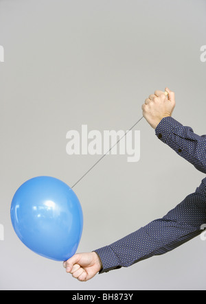 Männerhände einen Ballon platzen Stockfoto