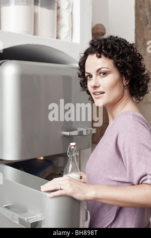Eine Frau, die Milch in den Kühlschrank stellen Stockfoto