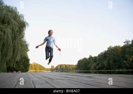 Ein Mädchen auf einem hölzernen Steg überspringen Stockfoto