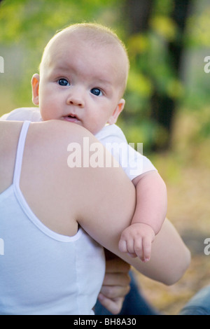 Einen kleinen Jungen, die von seiner Mutter, über die Schulter Blick durchgeführt werden Stockfoto