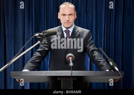 Ein Mann in einem Anzug steht an einem Lesepult Stockfoto