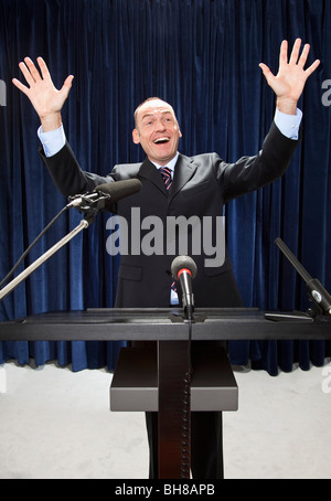 Ein Mann in einem Anzug an einem Lesepult gestikulieren Stockfoto