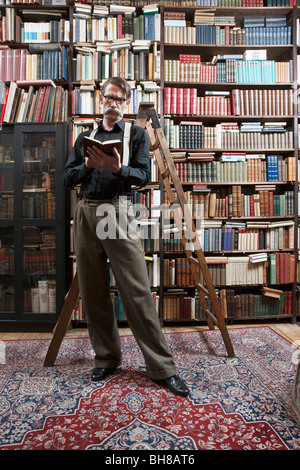 Ein Mann steht in einer Buchhandlung ein Buch zu lesen Stockfoto
