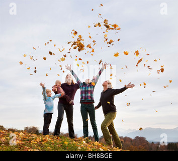 Familie Herbst wirft Blätter in Luft Stockfoto