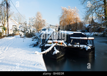 Narrowboats vertäut entlang der gefrorenen Kennet und Avon Kanal im Winter in Aldermaston Wharf, Berkshire, Großbritannien Stockfoto