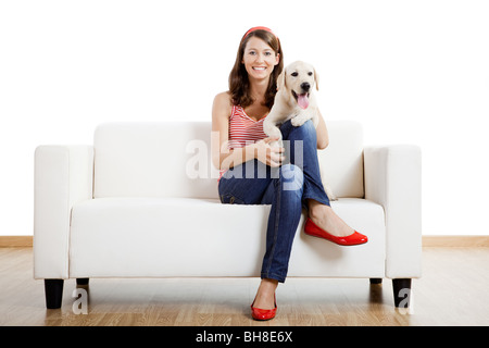 Junge schöne Frau zu Hause mit ihrem niedlichen Hund Stockfoto