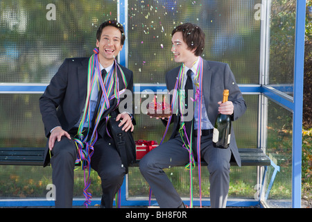 Geschäftsleute sitzen an Haltestelle, Party set Stockfoto