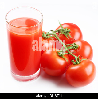 Glas Tomatensaft und reife Tomaten, isoliert auf weiss Stockfoto