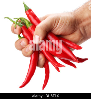 Faust komprimiert mehrere rote Chilischote auf weißem Hintergrund Stockfoto