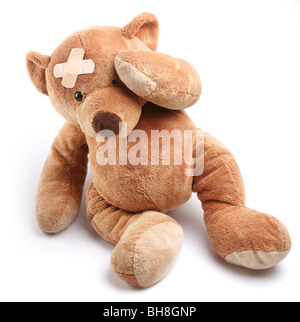 Krank Teddybär mit Gips auf den Kopf. Isoliert auf weißem Hintergrund. Stockfoto