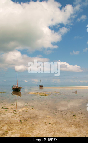 hölzerne Fischerboote untätig bei Ebbe auf dem Sand spucken vor Nungwi Beach in Sansibar. Sky schließt in den ruhigen Gewässern. Stockfoto