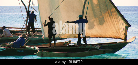 einheimischen Fischer auf einem hölzernen Dhau-Boot Takelage zu organisieren, wie sie landen am Strand von Nungwi in Sansibar, ihre Tage Angeln Fang zu verkaufen Stockfoto