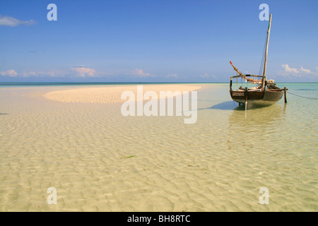 Eine verankerte Segelboot ruht auf dem türkisfarbenen kristallklaren Meer auf Sand spucken bei Ebbe im tropischen Paradies von Zanzibar beach Stockfoto