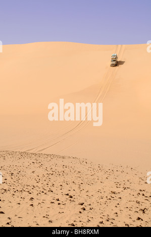 Eine Wüsten Safari Land Cruiser 4x4 Jeep Wappen eine riesige Sanddüne im Sandmeer der Westlichen Wüste, ägyptische Sahara, Ägypten. Stockfoto
