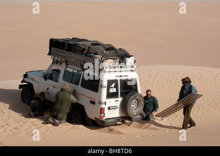 Eine Wüsten Safari Land Cruiser 4x4 Jeep wird in einem Patch von weichem Sand im Sandmeer der Westlichen Wüste, ägyptische Sahara, Ägypten stecken. Stockfoto