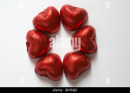 Herzförmige Pralinen in einem Ring Kreis auf weißem Hintergrund angeordnet - ideal für Valentinstag, Valentinstag Stockfoto