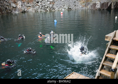 Taucher Ausbildung in gefluteten Steinbruch mit Diver springen im tiefen Wasser bei Vivian Steinbruch Diving Center, Llanberis, Gwynedd, North Wales, UK. Stockfoto