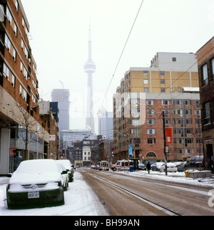 Schnee auf geparkte Autos und Straßenbahnlinien n McCaul Street und dem CN Tower Toronto Kanada KATHY DEWITT Stockfoto