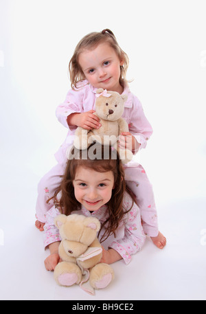 Schwestern im Pyjama mit ihren Teddys. Stockfoto