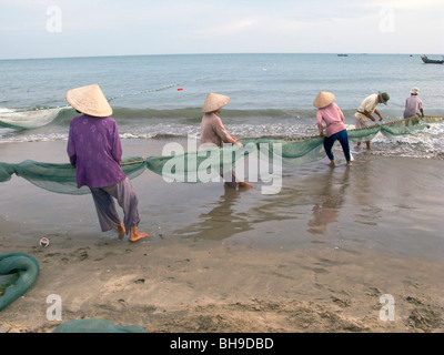 VIETNAM FRAUEN AUS CO-OPERATIVE CASTING FISCHERNETZ IM MEER IN DER NÄHE VON MUI NE Stockfoto