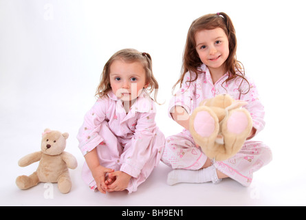 Schwestern im Pyjama mit ihren Teddys. Stockfoto