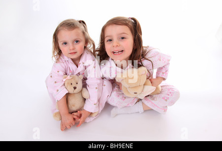 Schwestern im Pyjama mit ihren Teddys. Stockfoto