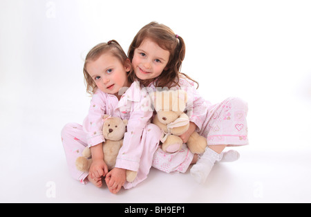 Schwestern im Pyjama mit ihren Teddys. Stockfoto