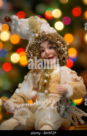 A Court Jester Urlaub vor ein beleuchteter Weihnachtsbaum Dekoration. Stockfoto