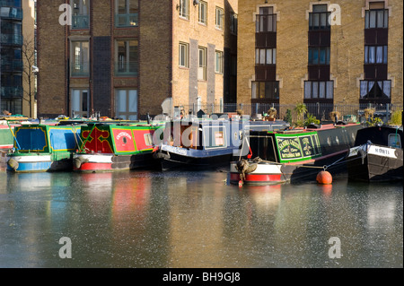 Langbooten, Narrowboats oder Schiffe oder Boote im Battlebridge Becken Regents Kanal mit Wasser eingefroren & vereist Stockfoto