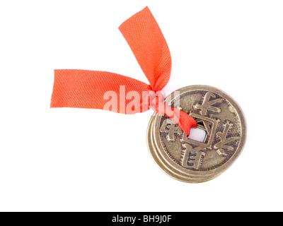 Drei chinesische Münzen Glück gebunden mit rotem Band als Symbol für Wohlstand und Reichtum - Schuss über weißem Hintergrund Stockfoto