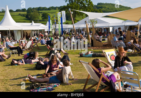 Massen von Menschen entspannen und chillen sitzen auf dem Rasen draußen in der Sonne Hay Festival 2009. Stockfoto