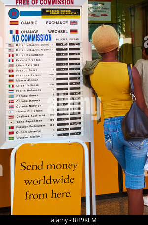 Frau lehnte sich gegen internationale Währung Wechselkurs Board vor Western Union Büro in Fuengirola, Spanien