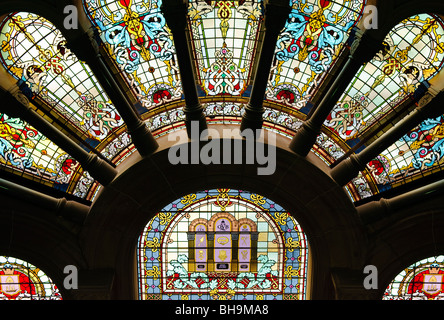 Queen Victoria Building Buntglasfenster Sydney Australien // SYDNEY, Australien – Buntglasfenster im Einkaufszentrum Queen Victoria Building im Geschäftsviertel von Sydney. Das Queen Victoria Building, ein berühmtes architektonisches Meisterwerk, steht majestätisch im Herzen von Sydney. Dieses im späten 19. Jahrhundert erbaute Gebäude im romanischen Stil beherbergt eine Reihe von exklusiven Geschäften, Cafés und Boutiquen. Das große Innere des Gebäudes verfügt über atemberaubende Buntglasfenster, komplizierte Fliesen und eine prächtige zentrale Kuppel, was es zu einem beliebten Ziel für Shopping und Sightseeing macht. Stockfoto