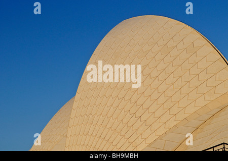 Sydney Opera House Sail Detail Sydney Australien | SYDNEY, Australien – Eine Nahaufnahme der Schale des Sydney Opera House zeigt das Chevron-Muster seiner Keramikfliesen in harkendem Morgenlicht. Der dänische Architekt Jørn Utzon spezifizierte 1.056.006 Fliesen des schwedischen Herstellers Höganäs, wobei er weiß glänzend und Creme matt abwechselte, damit sich das Dach bei Regen selbst reinigt und den Ton mit dem Hafenlicht verändert. Das Gebäude wurde 1973 nach sechzehn Jahren Planung und Bau eröffnet. Stockfoto