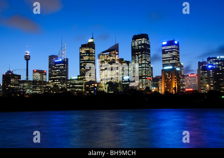 Sydney Skyline von Mrs. Macquarie's Point Australien // SYDNEY, Australien – Blick in die Abenddämmerung auf Sydneys Skyline von Mrs. Macquarie's Point, einem beliebten Aussichtspunkt im Hafen von Sydney. Das berühmte Sydney Opera House mit seinen markanten segelförmigen Muscheln ist im Vordergrund zu sehen, mit der Sydney Harbour Bridge, die den Hafen überspannt. Mrs. Macquarie's Point befindet sich in den Royal Botanic Gardens und ist nach Elizabeth Macquarie, der Ehefrau des ehemaligen Gouverneurs der Kolonialzeit Lachlan Macquarie benannt. Stockfoto