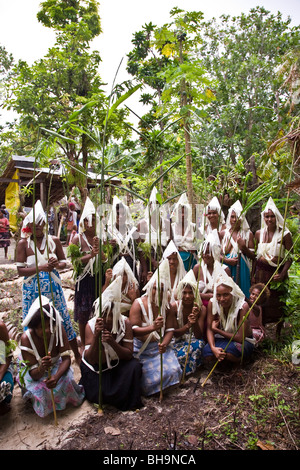 Gruppe von melanesischen Männer und Frauen tragen traditionelle weiße Fransen Kopfschmuck Pose für Kamera Stockfoto