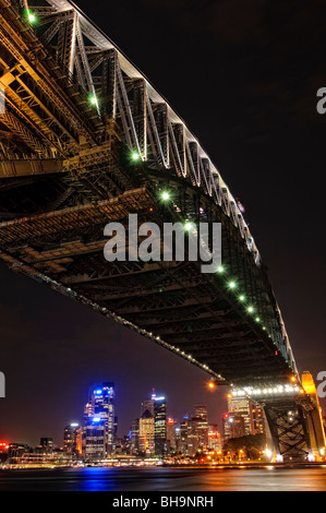 Sydney Harbour Bridge und City Skyline bei Nacht Sydney // SYDNEY, Australien – Nachtaufnahme der Sydney Harbour Bridge und Skyline der Stadt Sydney mit Blick zurück in Richtung Dawes Point und von Milsons Point. Die ikonische Brücke ist hell beleuchtet, und die pulsierenden Lichter der Stadt spiegeln sich auf dem ruhigen Wasser des Hafens von Sydney wider. Stockfoto