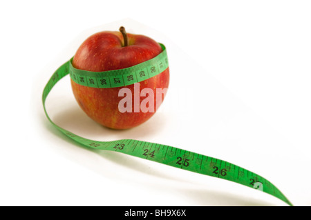 Frische Apfel und Maßband auf weißem Hintergrund mit Schwerpunkt am 24./25. Diät und gesunde Lebensweise Konzept Stockfoto