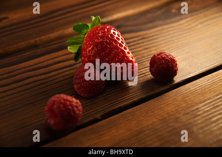 “Living longer- for long, healthy lives” concept. Berries on wooden rustic background: strawberry and raspberry. Stockfoto