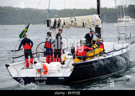 Rolex Sydney to Hobart Yacht Race Sydney Australien | SYDNEY, Australien – Crew-Mitglieder arbeiten am Heck der Yacht Quest im Hafen von Sydney vor dem Start des Rolex Sydney to Hobart Yacht Race 2009. Der CYCA-Schriftzug auf dem Rumpf identifiziert den Heimclub des Bootes als Cruising Yacht Club of Australia, der seit 1945 das 628-Meilen-Rennen organisiert; unter der Führung von Bob Steel belegte Quest Platz 16 der Online-Auszeichnungen. Stockfoto