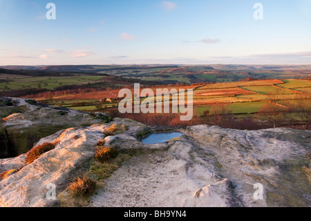 Blick auf Ackerland vom birchenfarbig Rand im Peak District als am frühen Morgen Sonne leuchtet das Tal Stockfoto