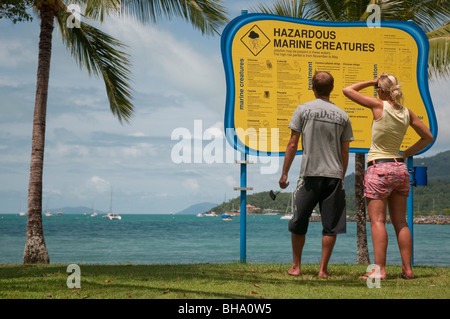 Touristen auf der Suche um gefährliche marine Kreatur Warnung am Airlie Beach in Queensland Stockfoto