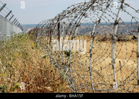 Ein Stacheldraht-Coil-Zaun, der die Grenze zwischen dem Yarmouk-Tal in Jordanien und den besetzten Golanhöhen in Israel im Nahen Osten abgrenzt. Stockfoto