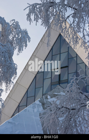 Moderne Kirche hinter gefrorenen eisigen verschneiten Bäumen in Hyvinkää, Finnland Stockfoto